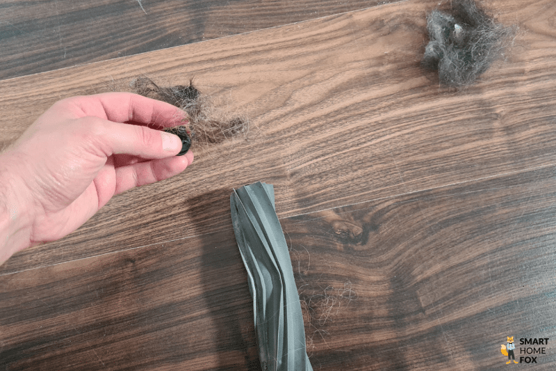 Die Hauptbürste des Dreame L20 Ultra wird von Haaren befreit.